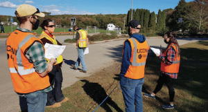 group of people in orange vests and masks looking at landscape