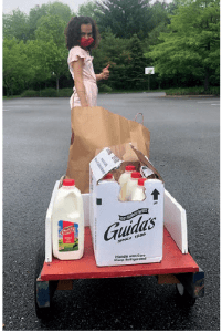 girl pulling wagon of millk