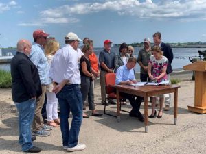 Gov. Lamont signs the Shellfish Restoration Bill on July 23 as legislators and industry members look on