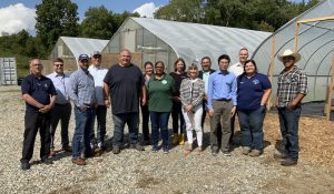 group standing in front of greenhouses