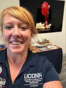 UConn Educator taking a selfie in front of the educational booth