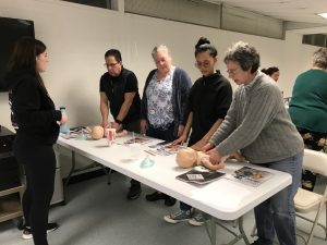 people practicing CPR on an infant