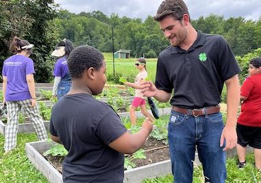 man and boy standing in garden looking at sprout