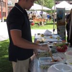 man preparing food at a table under a tent