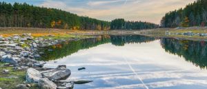 reservoir with fall foliage and sky reflecting in water