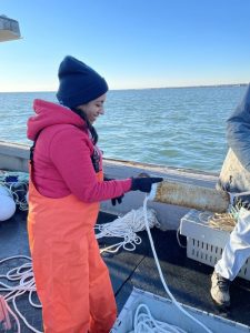 Anoushka cutting rope on a boat in the Ocean