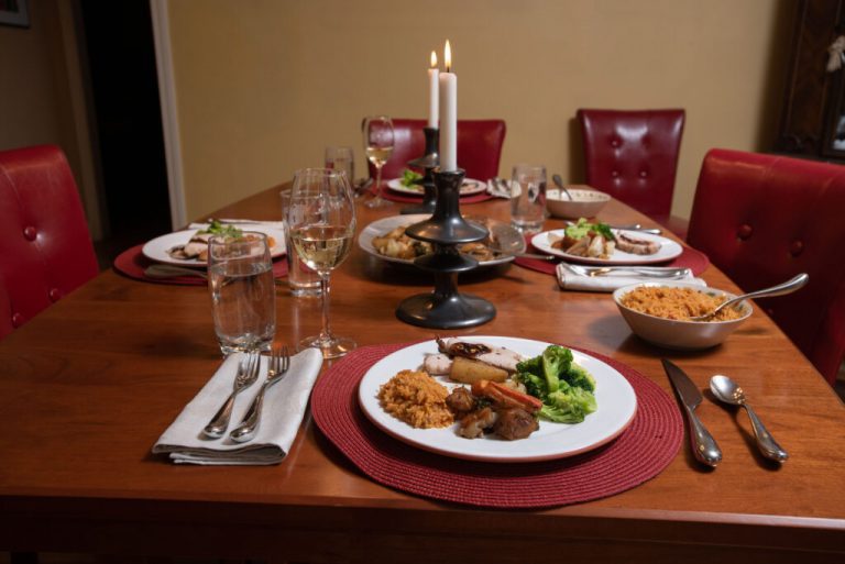 dinner table set for a holiday meal with candles in the middle