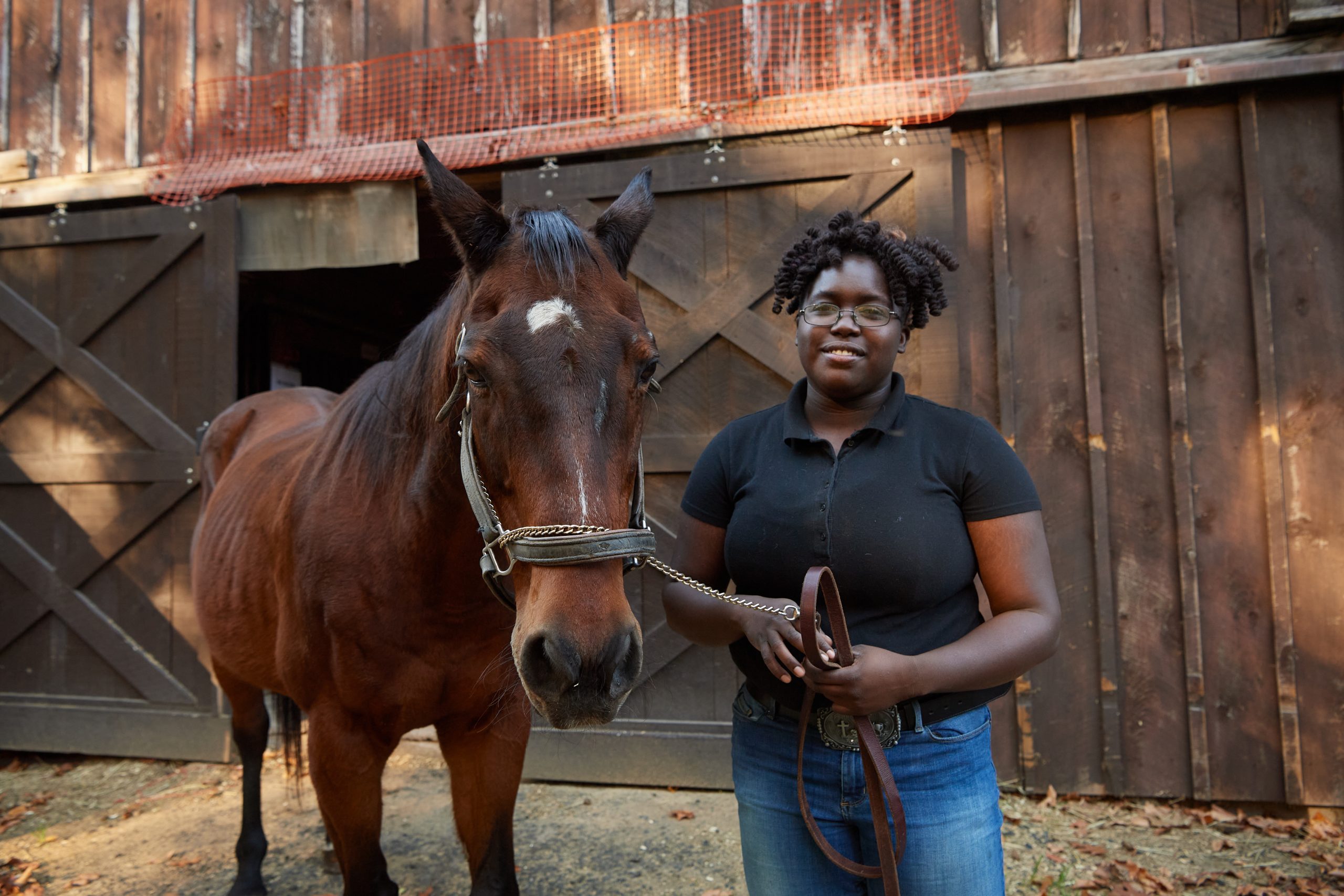 LaShawnda Phillips '20 (RHSA) '22 (CAHNR), with a horse named Handsome, at the Ebony Horsewomen Incorporated Equestrian and Therapeutic Center in Hartford on Nov. 8, 2021. (Peter Morenus/UConn Photo)
