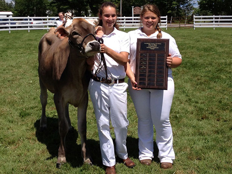 girls with a cow and plaque