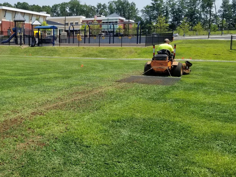 Person mowing a soccer field