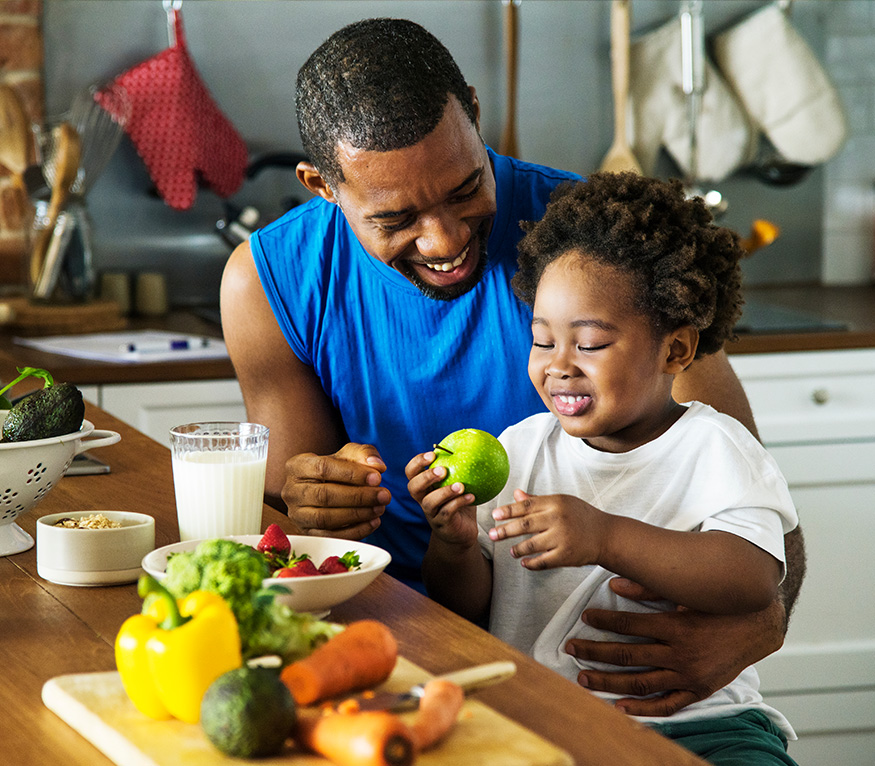 father and son sitting at a table eating fruit
