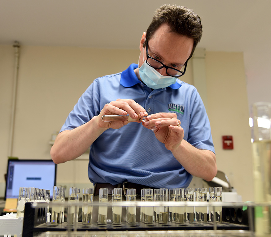 man in soil testing lab reviewing a sample