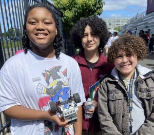 3 boys holding a robotic car