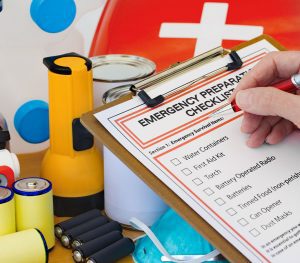 emergency supplies check list next to a flashlight and batteries.