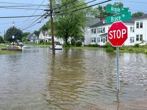Flooded road with a stop sign in a residential neighborhood