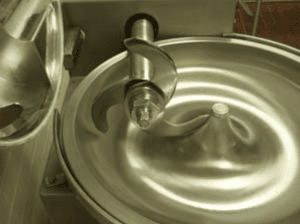 A close up image of the inside of the bowl part of a bowl chopper with the lid open.