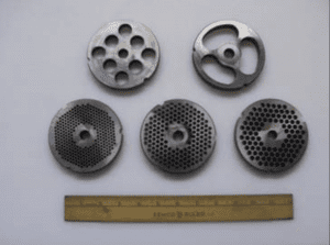 A collection of 6 circular metal meat grinding plates. A ruler is shown for scale.