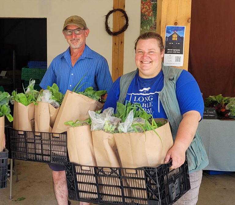 Long Table Farm-employees holding vegetables.