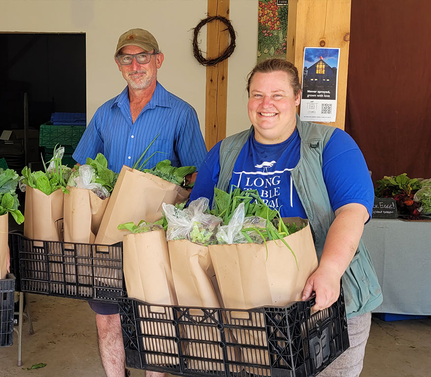 Long Table Farm-employees holding vegetables.