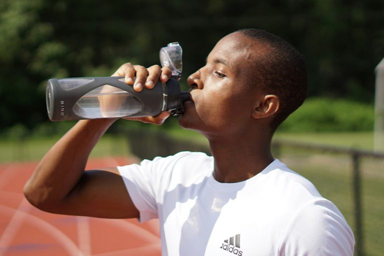 A man drinking out of a water bottle.