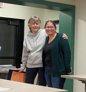 two women standing together and smiling